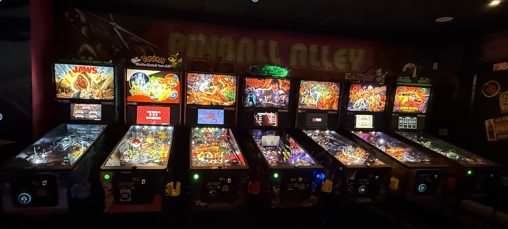 Row of pinball machines installed in a venue by Pinky's Rentals