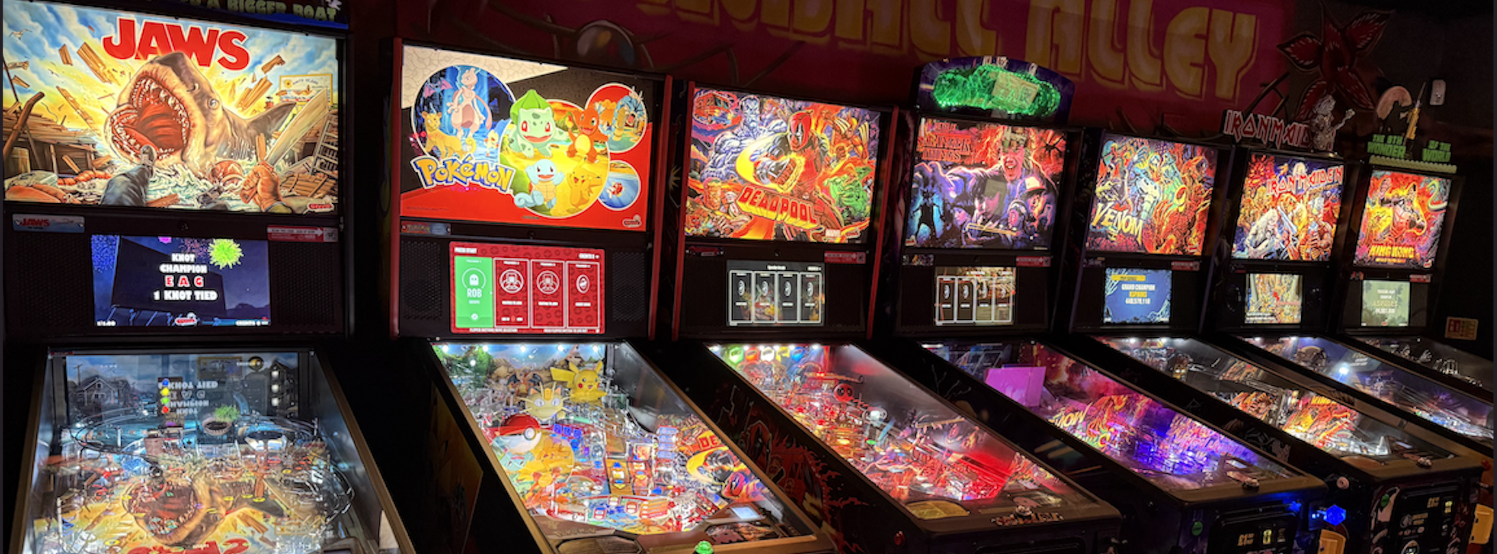 Row of arcade and pinball machines at Pinky's Rentals